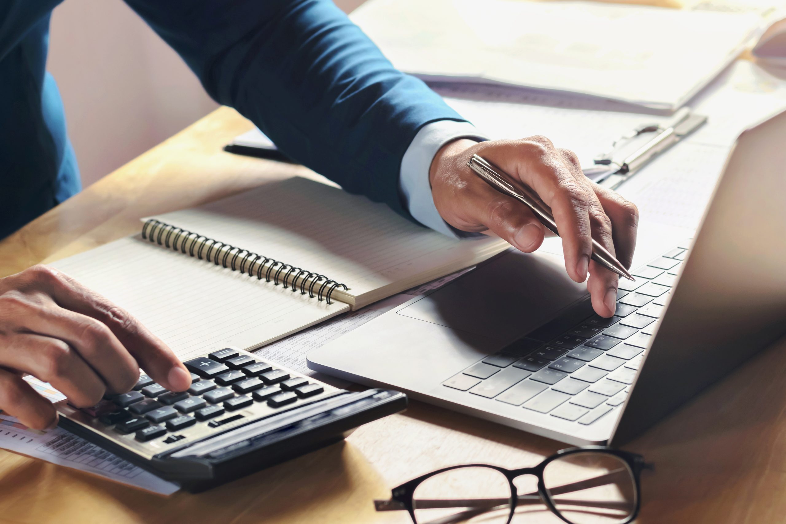 businessman working on desk with using calculator and computer in office. concept accounting finance